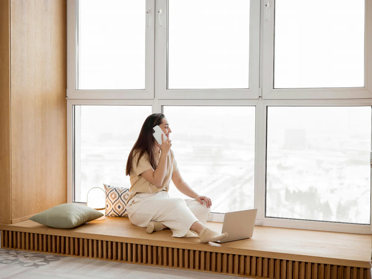 Ottawa homeowner sitting comfortably by a large Energy Star certified multi-pane window configuration during a snowy, cold winter season